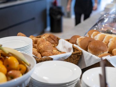 Ekmek sepetleri ve konukseverlik yemeği için kaplanmış yiyecek paketleriyle profesyonel kahvaltı servisi.