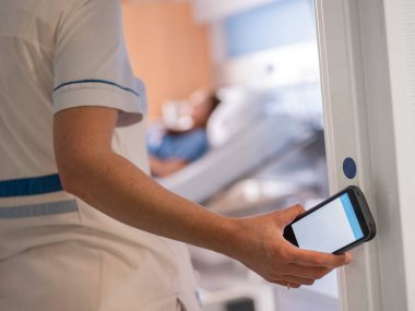 Hastane ortamında hasta bakımı koordinasyonu için mobil cihaz kullanarak arkadan sağlık çalışanı