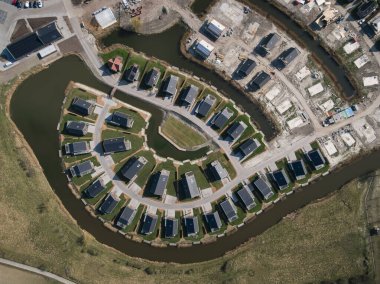 Suyla çevrili tamamlanmış evler ve inşaatın hava görüntüsü