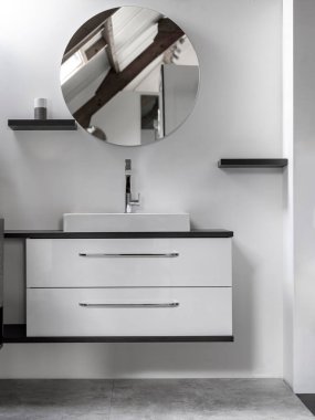 Beyaz çekmeceli modern yüzen kibir ve temiz banyo içinde yuvarlak ayna.