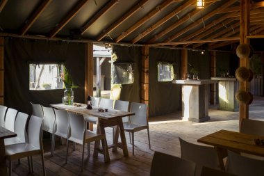 Ahşap fenerler ve geleneksel oturma düzeniyle köy restoranının içini geniş açıdan görebiliriz.