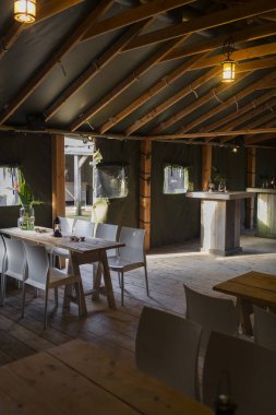 Kırsal restoran yemek odasında fener ışığı ve ahşap mobilya ile korunmasız kiriş tavanı