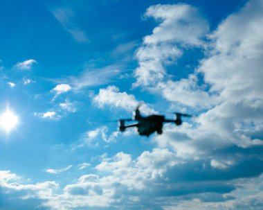 Parlak güneşe karşı siluet ve yüksek kontrastlı aydınlatma ile dramatik bulutlu gökyüzü