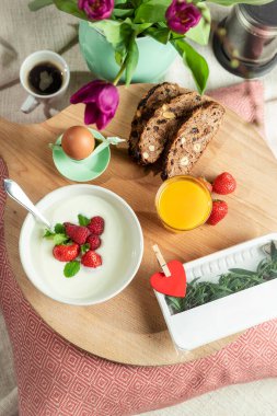 Ekmek, böğürtlen, meyve suyu, kahve, çiçekler, Sevgililer Günü ve Anneler Günü için tablet kalp içeren romantik bir kahvaltı.