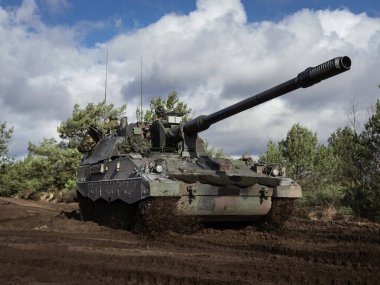 Düşük açılı PzH 2000NL topçu sistemi dramatik gökyüzü ile çamurlu arazide konumlandırıldı