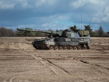 PzH 2000NL kendinden itişli havan topu mürettebatıyla kumlu eğitim sahasında