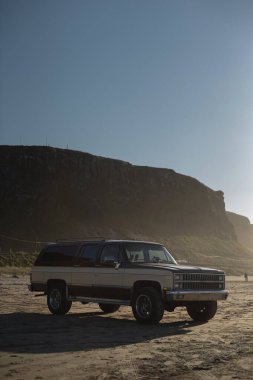 İrlanda sahilinde uçurum arkaplanı ve açık mavi gökyüzü olan klasik SUV konumu