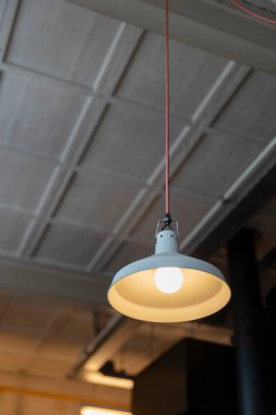 Tavandan sarkan beyaz kolye ve sıcak Edison ampulü.