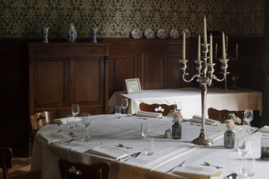 Mum ışığında yemek odası ve geleneksel koyu ahşap mobilyalar.