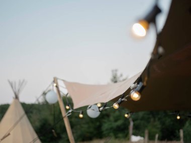 İp ışıkları olan çadır rahat bir gece atmosferi yaratıyor.
