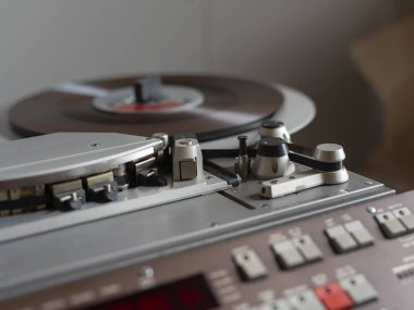 Klasik ses kayıt ekipmanlarını gösteren vinil plaklı profesyonel teyp.