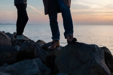 Altın saat keşfi sırasında kayalık kıyı şeridinde insanların ayakları