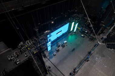 LED ekranlar ve teknik ekipmanlarla sahne kurulumunu gösteren büyük konser salonunun havadan görüntüsü