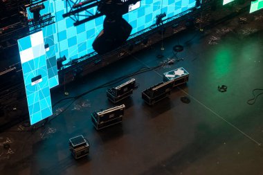 Konser salonunun zemininde düzenlenmiş büyük LED ekran panelleri ve ekipman çantalarının hava görüntüsü