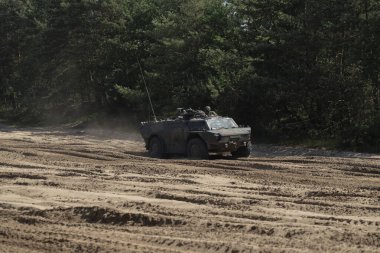 Fennek keşif aracı orman zeminli kumlu arazi boyunca manevra yapıyor.