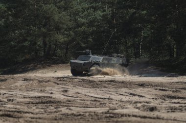 Zırhlı keşif aracı askeri tatbikat sırasında tozlu arazide manevra yapıyor.