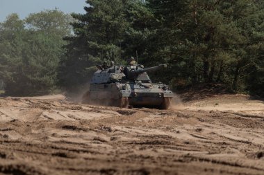 Oto itişli howitzer, çalışma ortamında toz iziyle alan eğitimi veriyor.