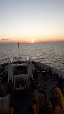 Denizin ortasındaki bir gemi güvertesinden gün batımının muhteşem görüntüsü. Gün batımında ufkun hemen üstünde güverteden panoramik görüntü