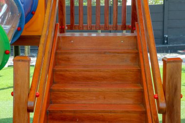Parlak gün ışığında, renkli bir oyun alanına çıkan tahta merdivenler, neşeli, neşeli bir ruh hali yaratıyor ve çocukluk, dinlenme ve açık hava aktiviteleriyle ilgili konular için mükemmel..
