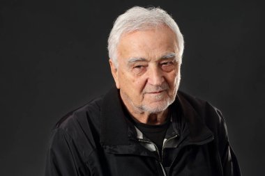 Yaşlı, beyaz saçlı, düşünceli ve nostaljik görünen, koyu renk kıyafetler giyen, esmer bir adamın duygusal portresi. Boşluğu kopyala