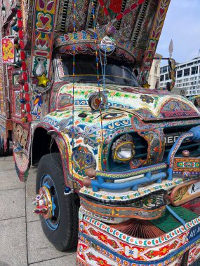 Karmaşık desenleri ve parlak renkleri olan, kentsel bir çevrede yerel sanatını sergileyen, çok güzel süslenmiş bir kamyonun çarpıcı yakın çekimi..