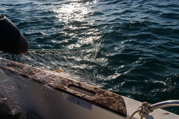 在布列塔尼的一艘船上捕鱼的人带着网回来 — 图库照片