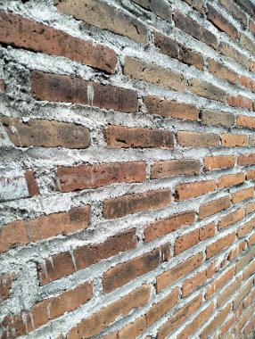 Çimento harçlı, kırsal kırmızı tuğla duvarın yakın çekimi, mimari ve tasarım kavramları için klasik bir zemin veya doku olarak mükemmel..