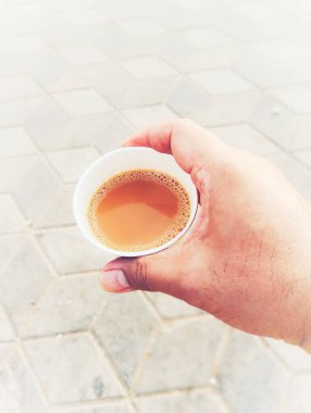 Bir fincan çay tutarken çekilmiş yakın bir fotoğraf. 