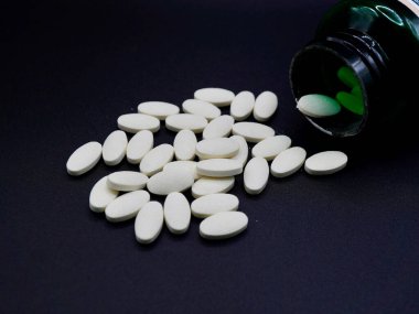 Yüksek detaylı olarak gösterilen B3 vitamini (niasin) tabletleri. Günlük besinlerde kullanılan temiz beyaz haplar, koyu yüzeye karşı keskin bir kontrastla. Sağlıkla ilgili görseller için ideal