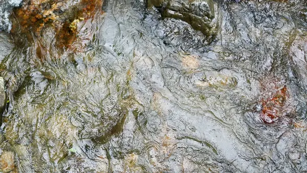 Dalgalar gibi dokuları olan pürüzsüz, dalgalı bir nehir yüzeyi. Çevresel markalaşma, spa promosyonları veya minimalist tasarımlarda arka plan kullanımı için harika