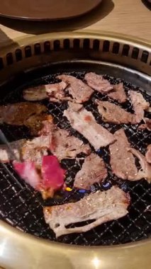 Açık ateşte kızartılan ince et dilimleri, duman, yağ damlaları ve altın dokular yemek, barbekü ve yemek pişirme temaları için mükemmeldir.