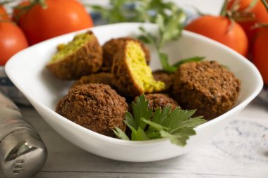 Falafel, ahşap arka planda domatesler