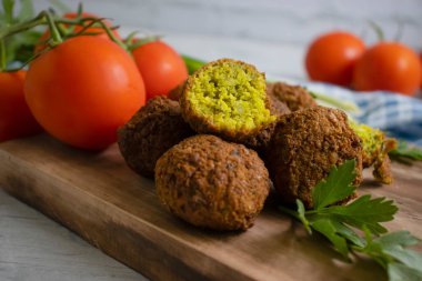 Falafel, ahşap arka planda domatesler