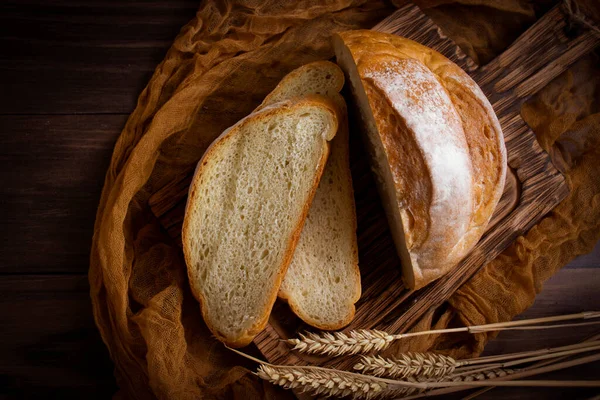 Eski ahşap arka planda taze kesilmiş beyaz ekmek.