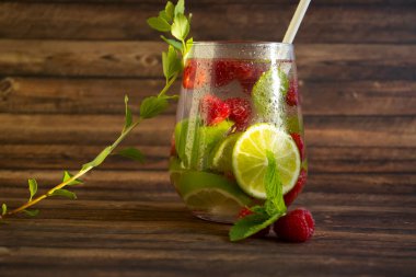 Nane aromalı soğuk su, ahududu, eski arkaplanda limon.