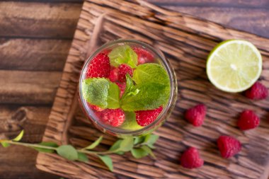 Nane aromalı soğuk su, ahududu, eski arkaplanda limon.