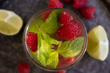 Nane aromalı soğuk su, ahududu, eski arkaplanda limon.