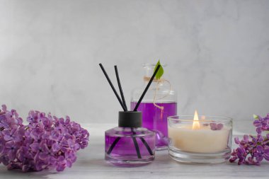 Ev için parfüm, leylak çiçeği, arka planda mum.