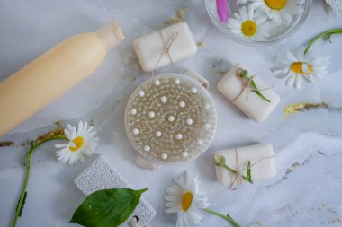 Masaj fırçası, sabun, sarı papatya çiçeği