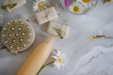 Masaj fırçası, sabun, sarı papatya çiçeği