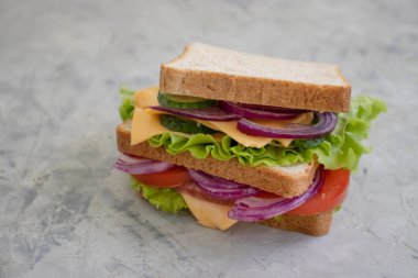 Peynirli sandviç, sosis, domates, marul, eski arkaplanda mavi soğan.