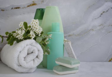 Shampoo cosmetic bottle, towel on a light background