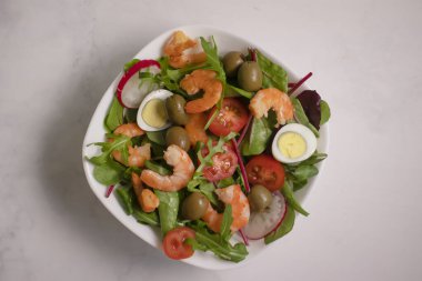 Salad with shrimps, tomatoes in a plate