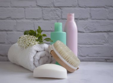 Cosmetic cream, flower, massage brush on old background