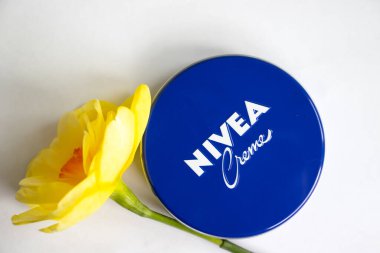 May 1, 2022 Ukraine city Kyiv jar of Nivea cream, narcissus flower on a colored background