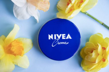 May 1, 2022 Ukraine city Kyiv jar of Nivea cream, narcissus flower on a colored background