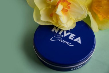 May 1, 2022 Ukraine city Kyiv jar of Nivea cream, narcissus flower on a colored background