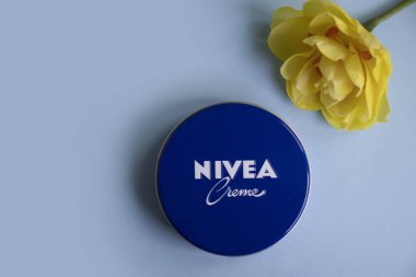May 1, 2022 Ukraine city Kyiv jar of Nivea cream, narcissus flower on a colored background