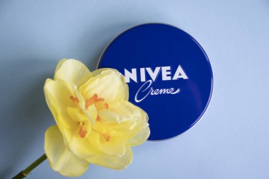 May 1, 2022 Ukraine city Kyiv jar of Nivea cream, narcissus flower on a colored background