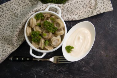 Dumplings with sour cream and herbs on an old background